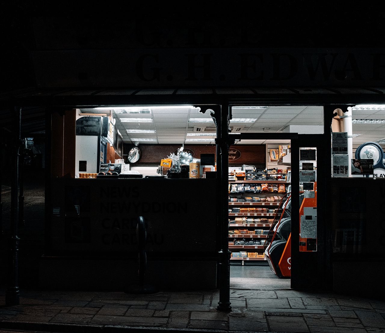 Free Exterior view of a convenience store at night, showcasing its well-lit interior. Stock Photo