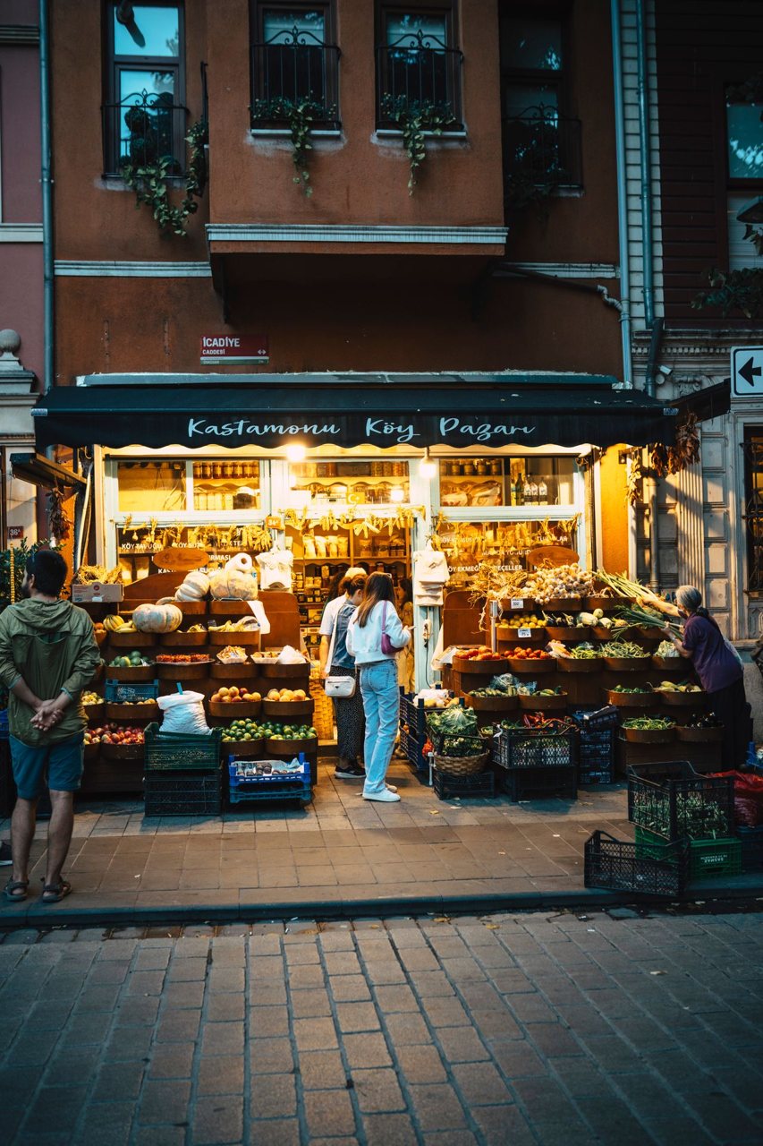 Free People shopping at Kastamonu shop at dusk, filled with fresh produce and warm lighting. Stock Photo