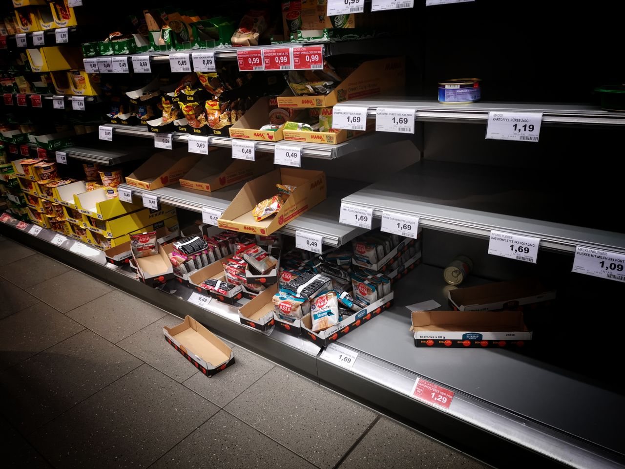 Free High angle of empty and full shelves in supermarket with price tags and cardboard boxes Stock Photo